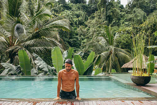 Handsome man coming out of swimming pool