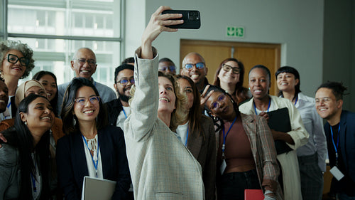 Diverse professionals smiling for a group selfie