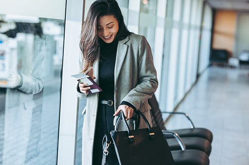 Businesswoman with luggage waiting at airport terminal