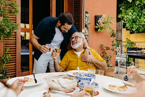 Family gathering for barbecue at outdoor patio enjoying quality time together