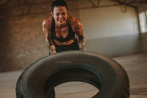 Tough woman doing tire flip workout