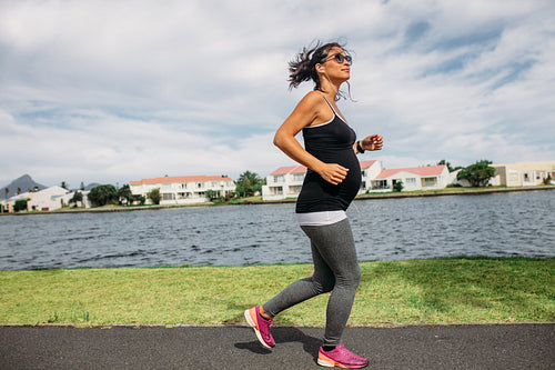 Pregnant woman walking along a lake