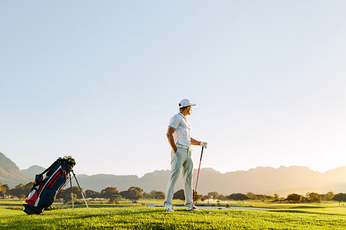 Professional male golfer with golf club at course