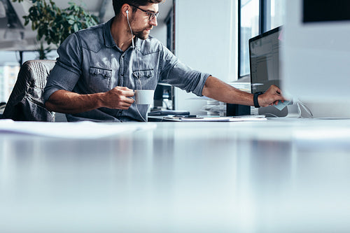Young designer taking a coffee break in office
