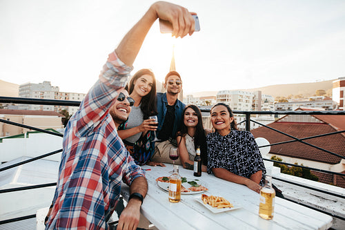 Group selfie at rooftop party