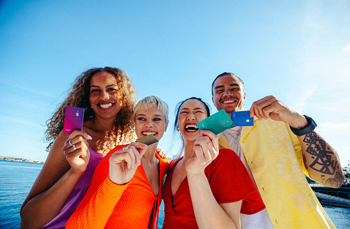 Students hold bank cards together outdoors for youth finance and student loan concepts