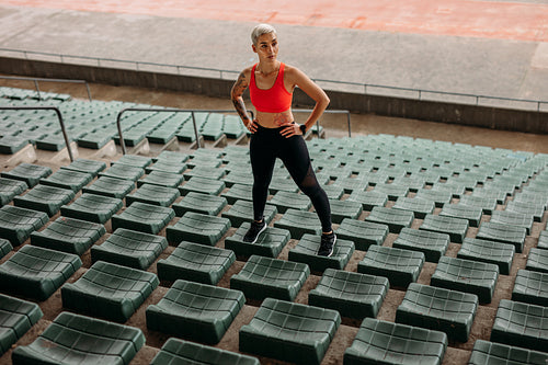 Woman athlete standing on the seats in the stands