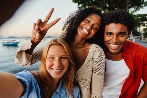 A joyful group of friends taking a selfie by the waterfront