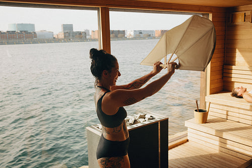 The spa sauna ritual highlights a woman using water and heat beside hot stones.