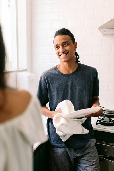 Man doing dishes with his girlfriend at home