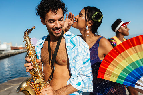 Carnival saxophonist and dancers by the sea