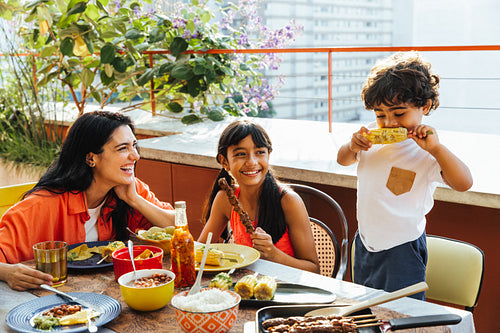 Happy family enjoying a shared meal together on an outdoor terrace