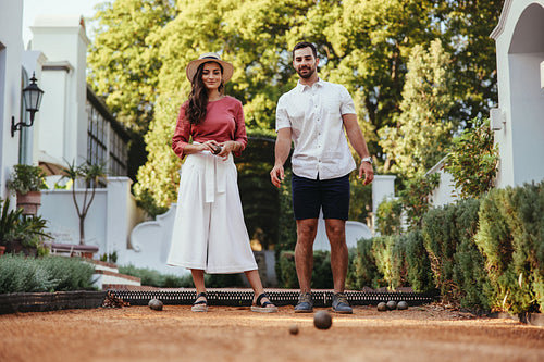 Young tourist couple playing boules at a hotel