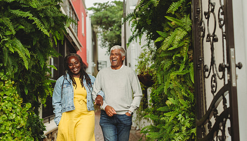 Happy senior couple laughing cheerfully while walking together