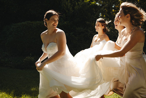 Bride and bridesmaids smiling and laughing in the outdoors