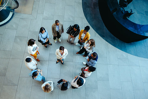 Overhead view of diverse group circle meeting in corporate setting