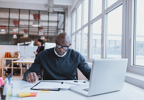 Young executive at his desk reading a document