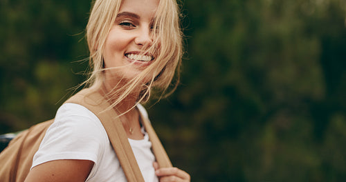 Portrait of a smiling woman explorer wearing a backpack