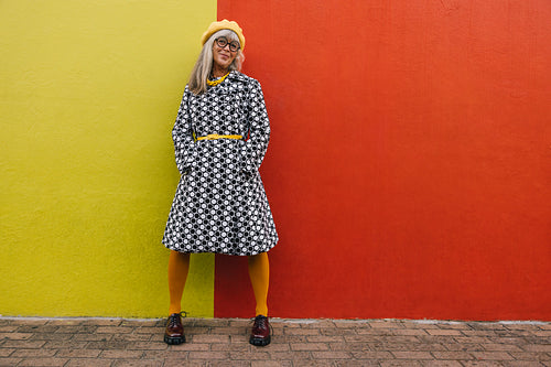 Mature woman standing against a colourful background