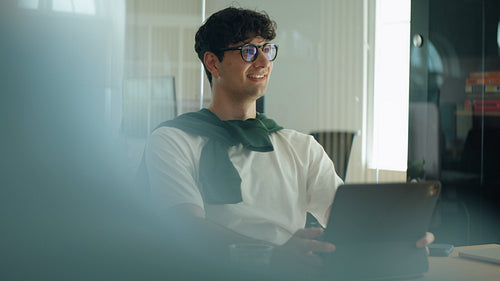 Man listens and smiles during a business meeting in a modern office