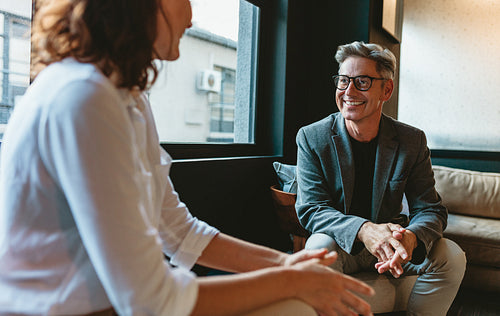 Businessman talking with female colleague in office lobby