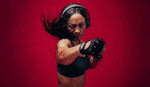 Boxer practicing her punches in a studio