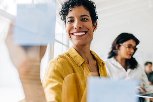 Creative business woman writing ideas on a sticky notes in an office