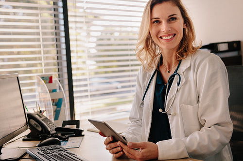 Friendly female doctor at her clinic desk