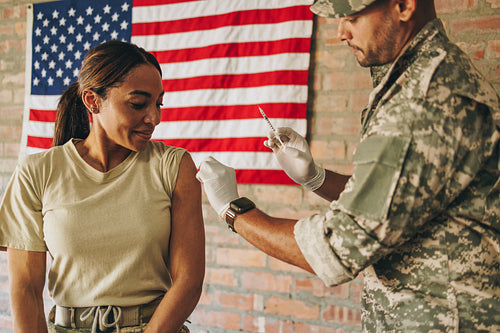 Female soldier receiving the flu shot in the army clinic