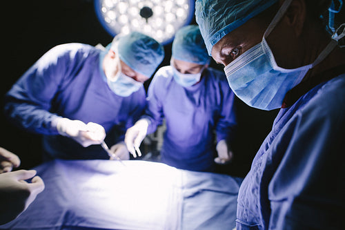 Surgeons performing surgery in operating theater