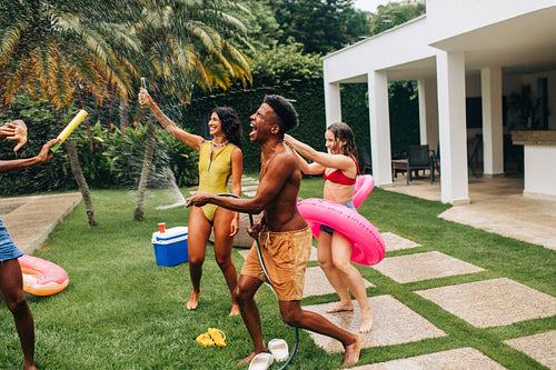 Friends celebrate backyard water fight and pool party