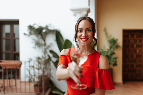 Woman toasting with a wineglass on a balcony