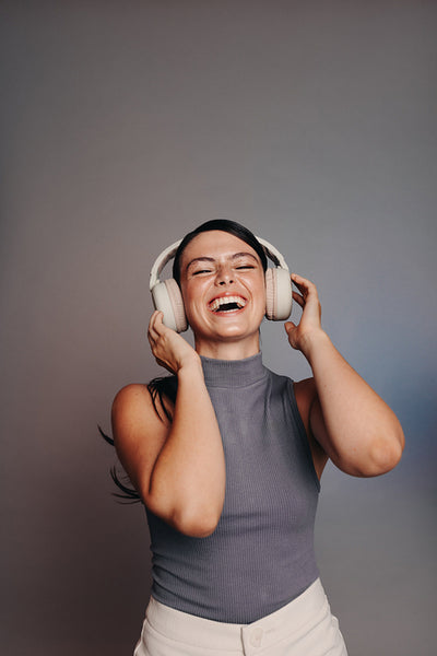 Woman laughing happily while wearing headphones