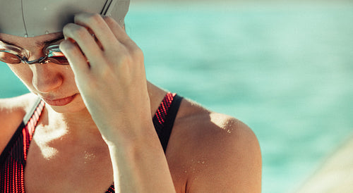 Swimmer adjusting her swim goggles