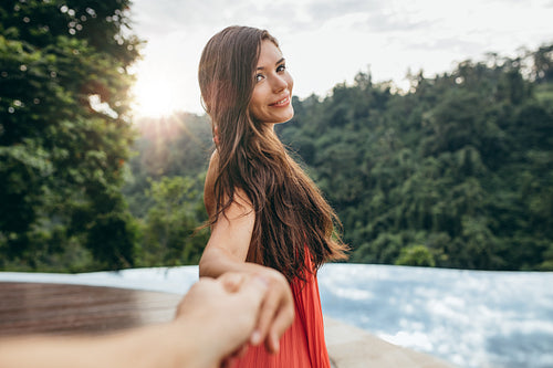 Beautiful girlfriend leading man to swimming pool