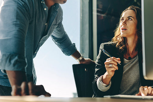 Two business partners discussing work in office
