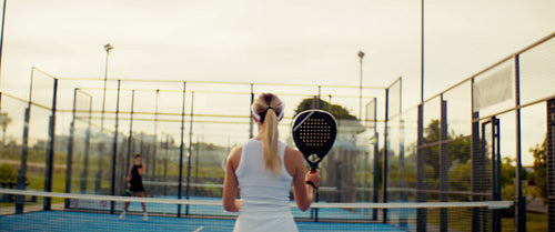 Padel Players Enjoying a Friendly Match on an Outdoor Court During a Sunny Summer Day