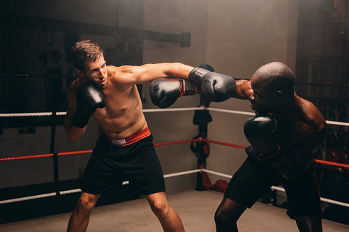 Male boxers fighting in a boxing ring
