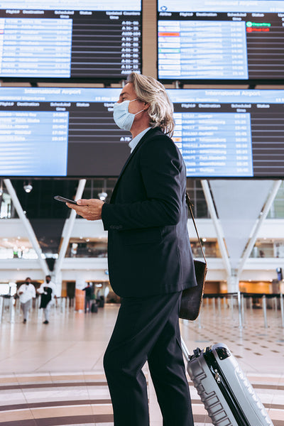 Businessman with luggage walking in airport terminal