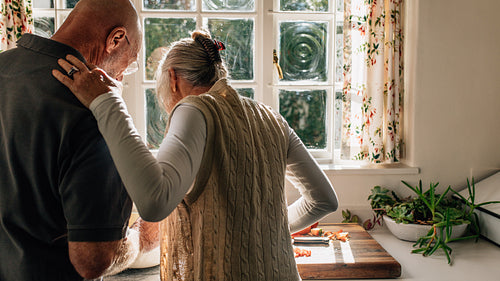 Couple standing in kitchen preparing food