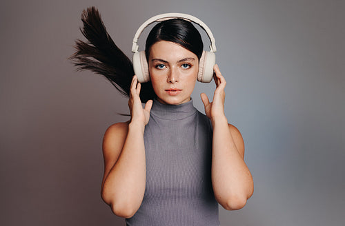Studio portrait of a young woman wearing wireless headphones