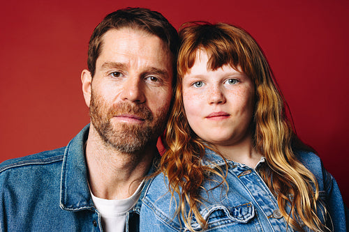 Portrait of a father and daughter in the studio shows a close family bond