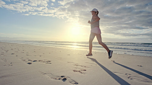  Woman running along the beach in morning