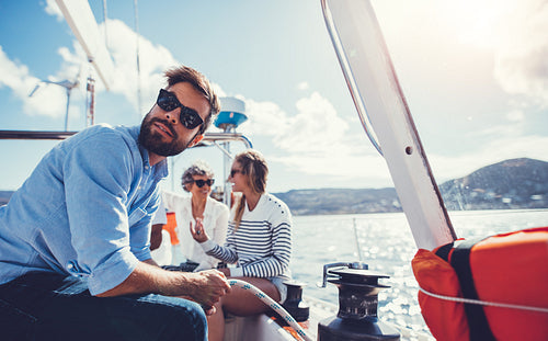 Young man sitting on the deck of a sailboat