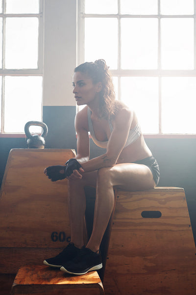 Muscular young woman relaxing after fitness training