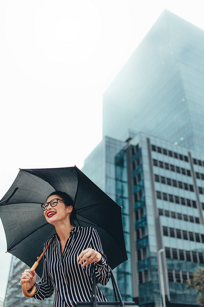 Businesswoman outdoors in the city with umbrella