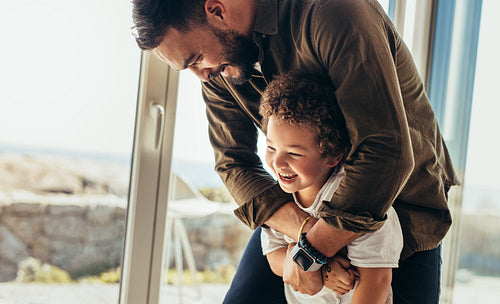 Man playing with his son at a beach house
