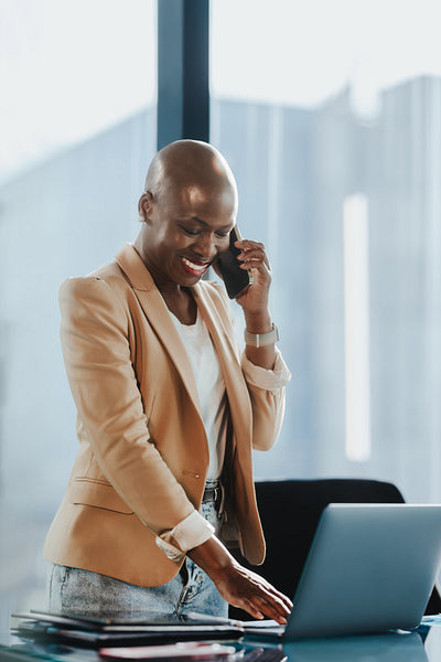 Happy business woman speaking on phone in a corporate office