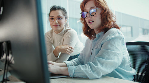 Female web developers working on a computer program in an office