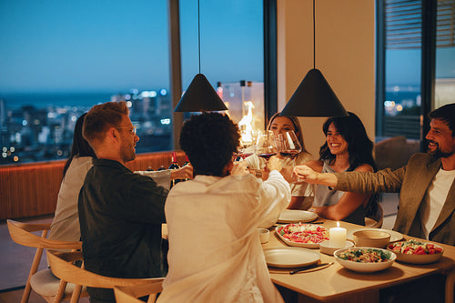 Friends enjoying a cozy evening with food and wine in a modern home